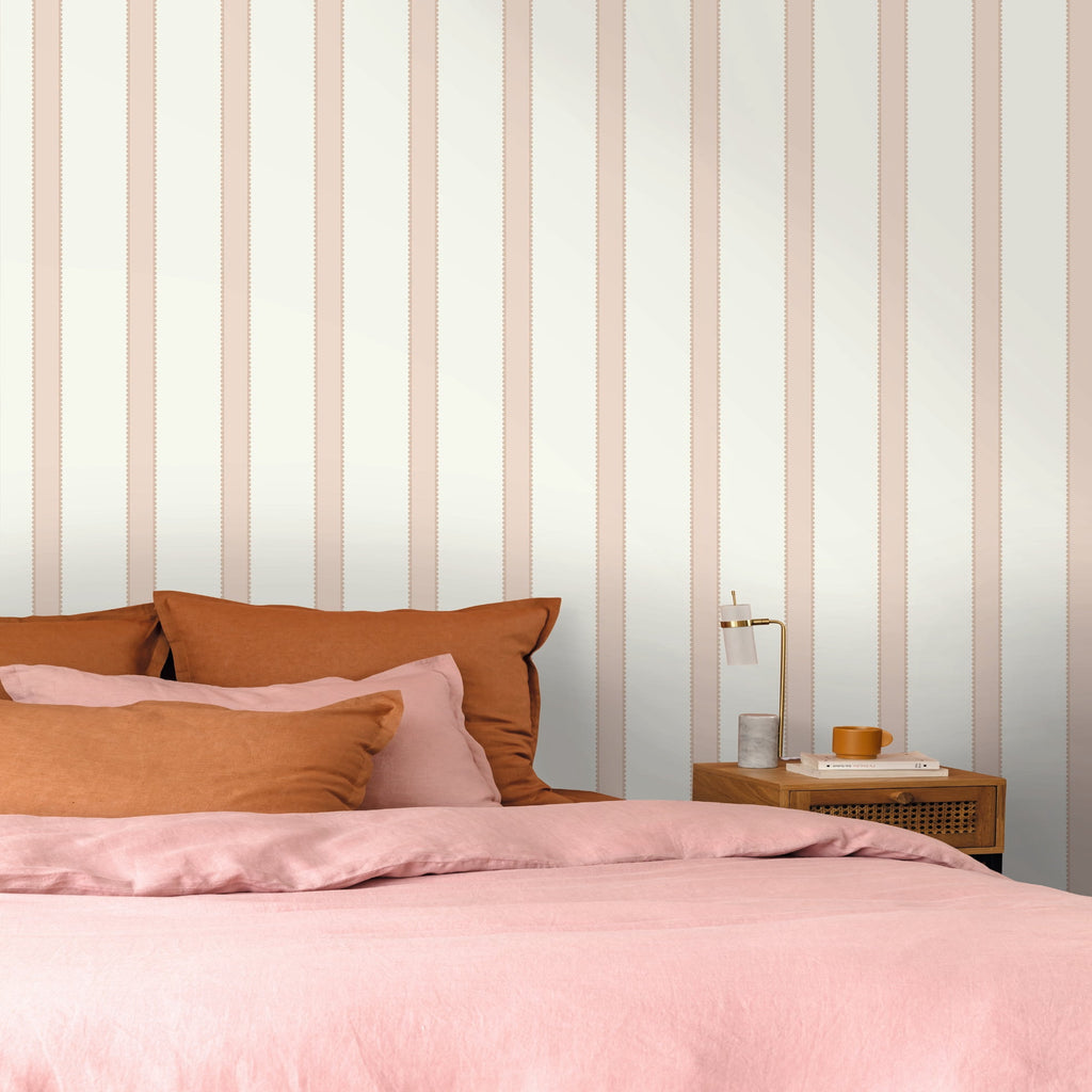 Bedroom with pink bedding and striped wallpaper