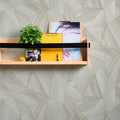 Wooden shelf with decorative items against a geometric-patterned wallpaper
