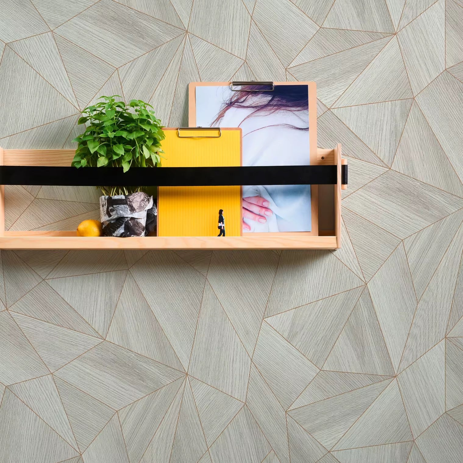 Wooden shelf with decorative items against a geometric-patterned wallpaper