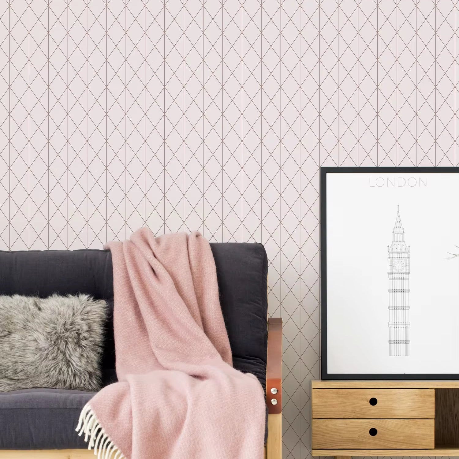 Living room with pink patterned wallpaper, gray sofa, pink throw blanket, and framed picture.