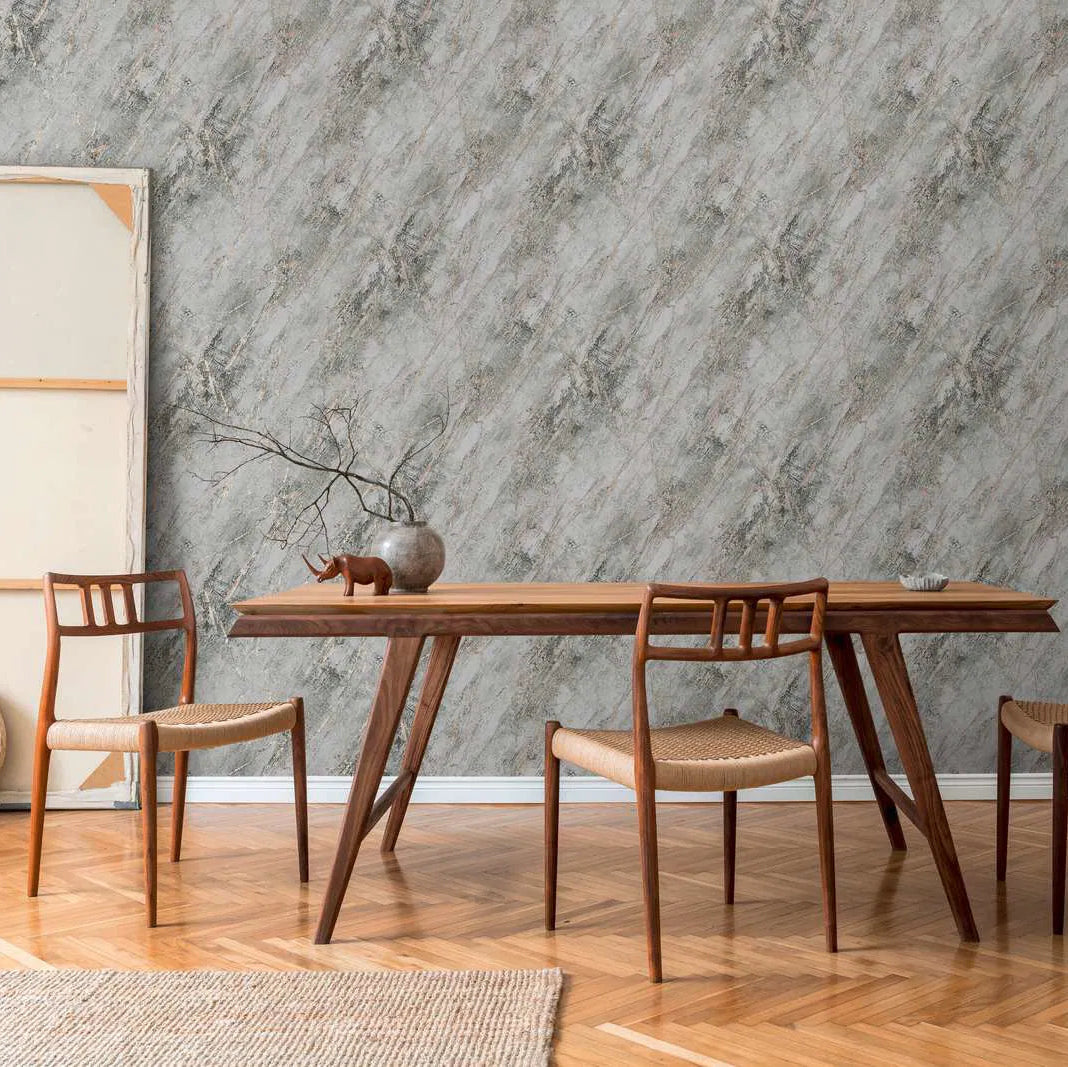 Dining area with wooden table and chairs against a gray marble wallpaper