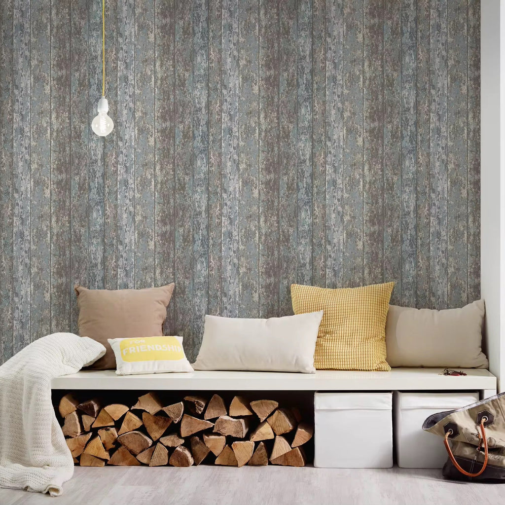 Bench with stacked firewood and colorful pillows against a textured wallpaper