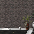 Decorative wallpaper with a subtle pattern on a wall behind a dark wooden desk.