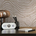 Desk setup with a clock, pen holder, and notebook against a wavy patterned wallpaper