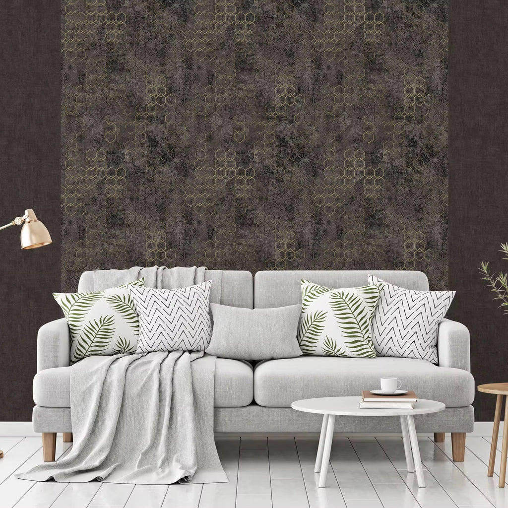 Gray sofa with patterned cushions against a dark wall with geometric design