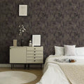 Neatly arranged bedroom with a dresser and bed against a patterned wall.