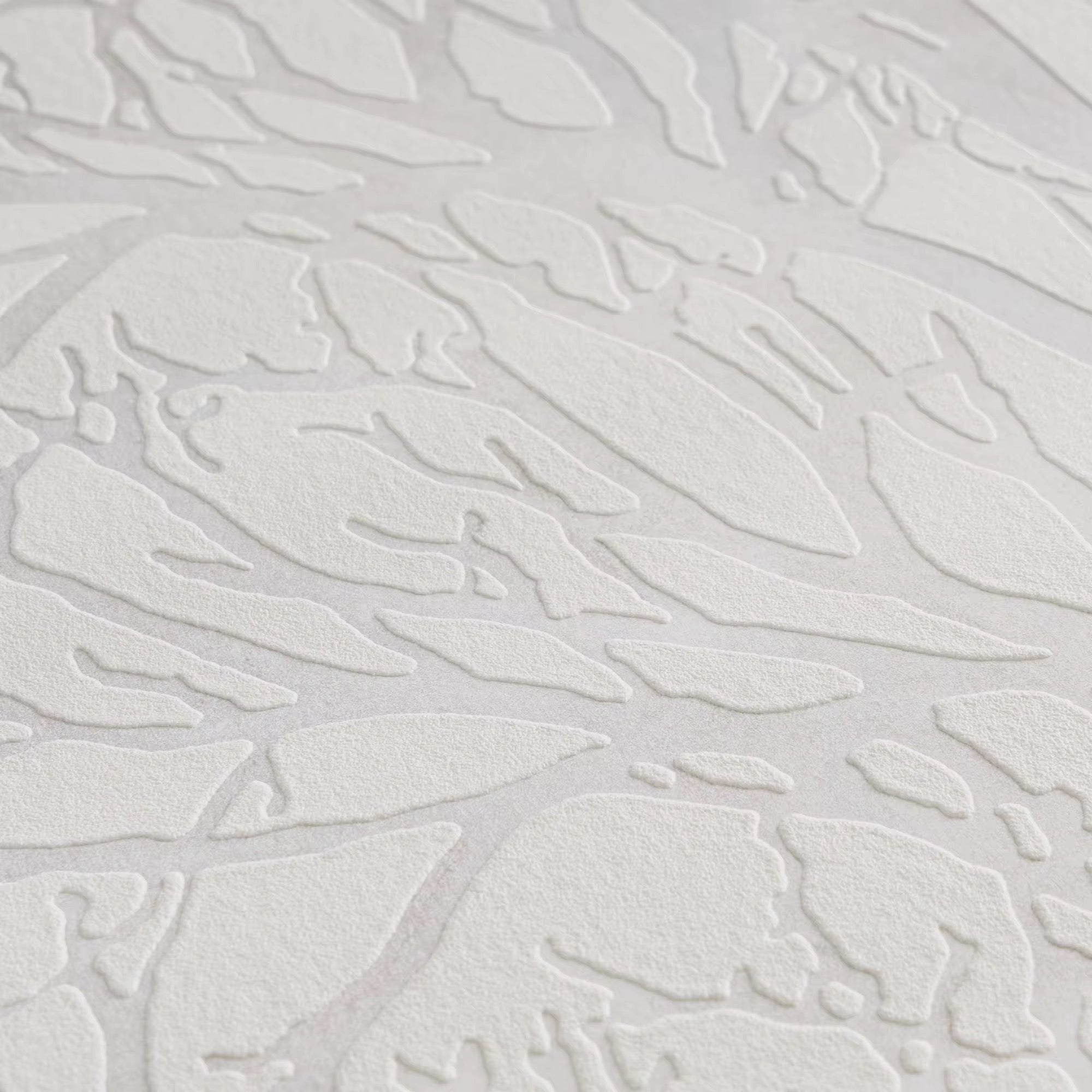 Textured white wallpaper with abstract leaf-like patterns