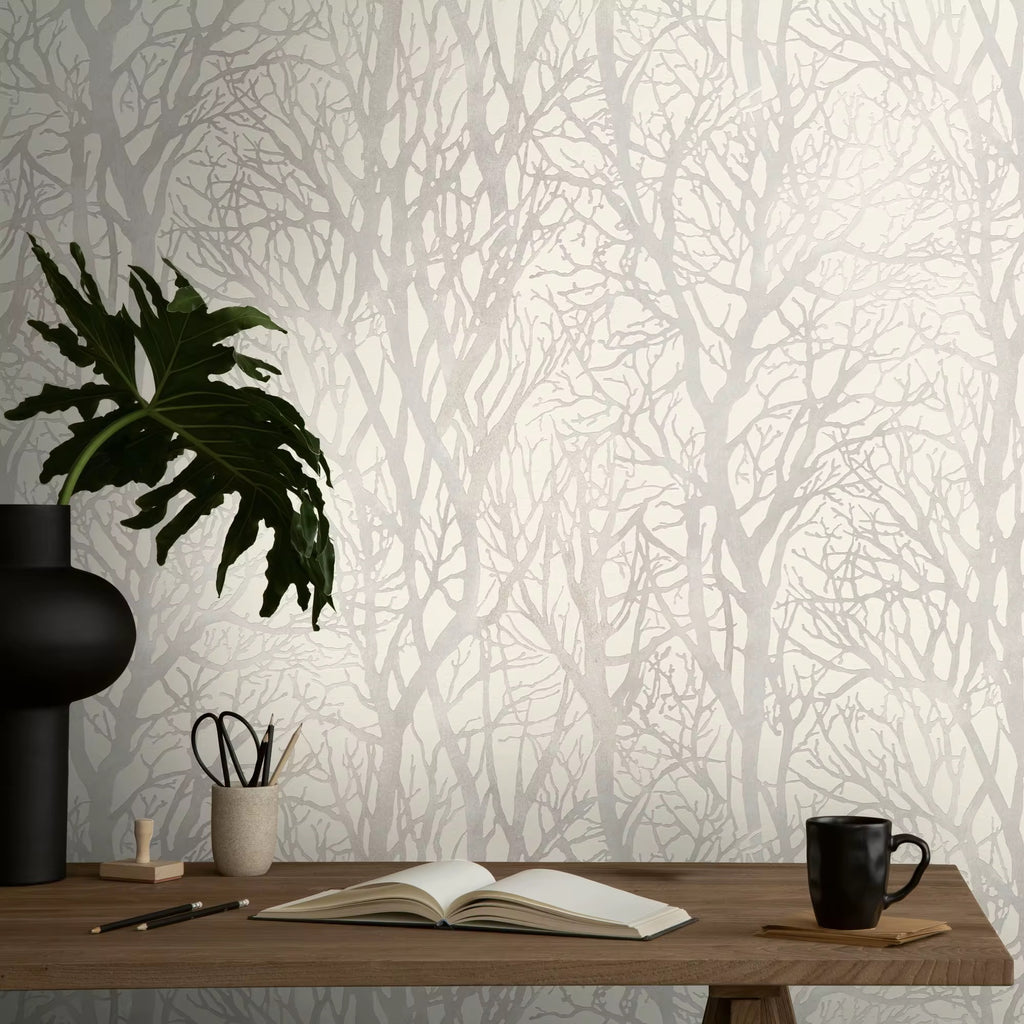 Wallpaper with tree design, desk with items against the wall