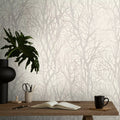 Wallpaper with tree design, desk with items against the wall