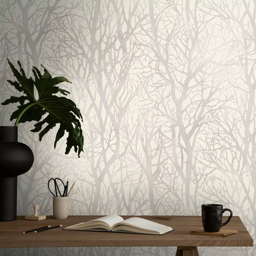 Wallpaper with tree design, desk with items against the wall